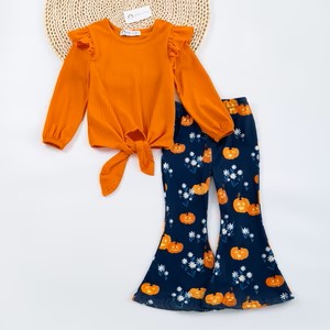A toddler outfit set with an orange top and blue pants with a pumpkin pattern. The top has a round neckline and short sleeves, and the pants have a wide flare with a mid-calf length.